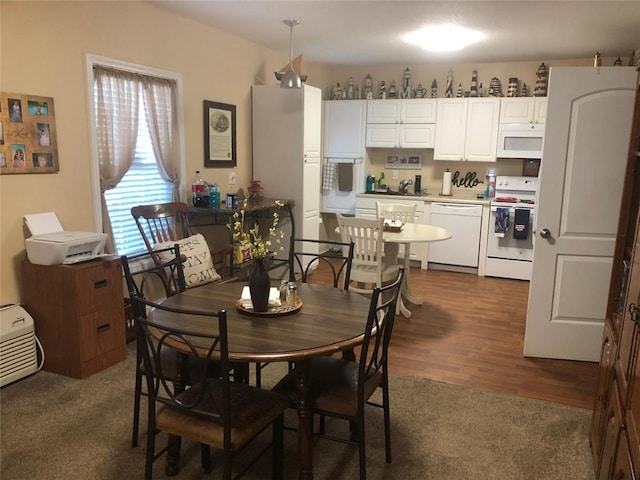 dining room featuring dark wood-style flooring and dark carpet