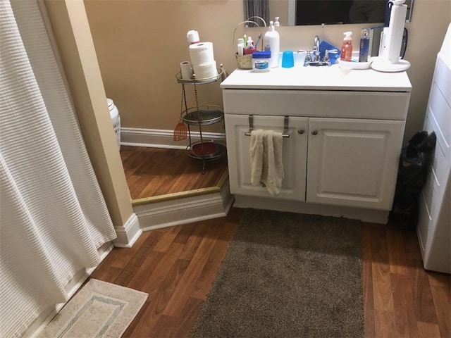 bathroom with vanity, baseboards, wood finished floors, and curtained shower