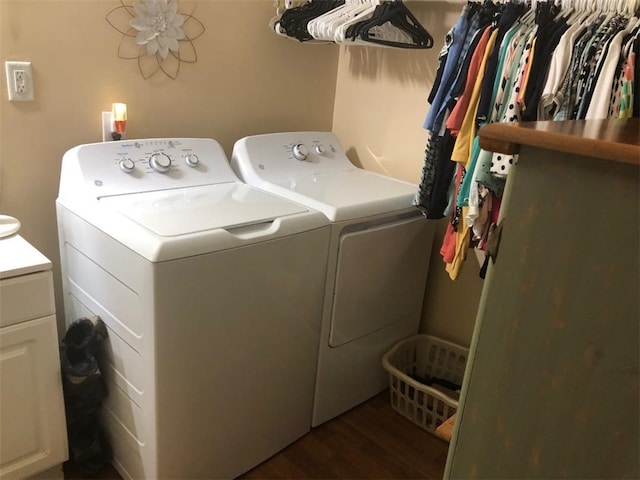 clothes washing area with dark wood-type flooring, cabinet space, and washing machine and clothes dryer