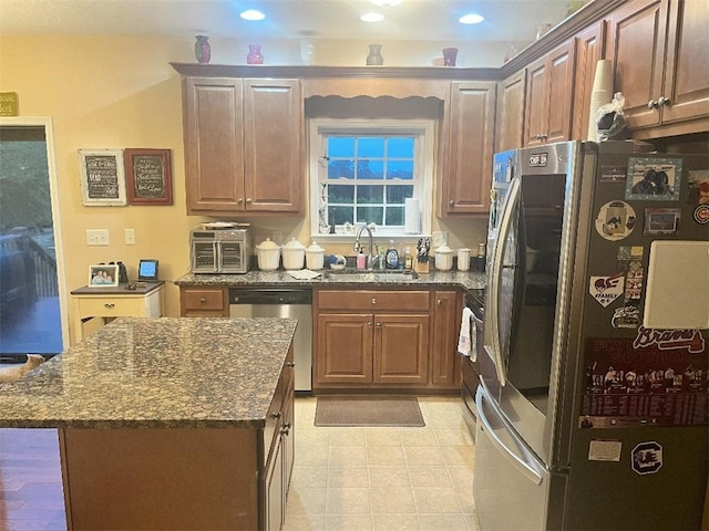 kitchen with a center island, a sink, dark stone countertops, stainless steel appliances, and recessed lighting