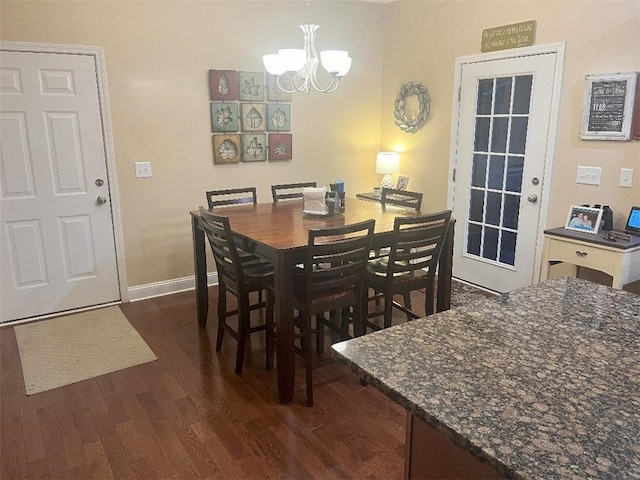 dining space featuring dark wood-style flooring, baseboards, and a chandelier