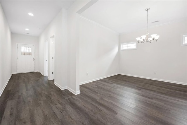 interior space with an inviting chandelier, crown molding, and dark hardwood / wood-style flooring