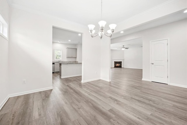 unfurnished dining area featuring ornamental molding, wood-type flooring, and ceiling fan with notable chandelier