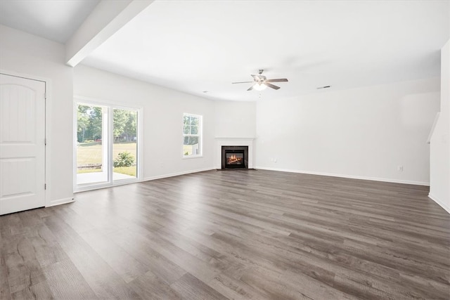 unfurnished living room featuring ceiling fan and dark wood-type flooring