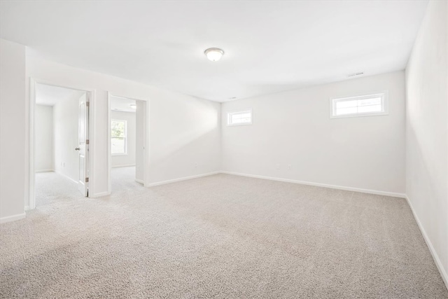 unfurnished room with a healthy amount of sunlight and light carpet