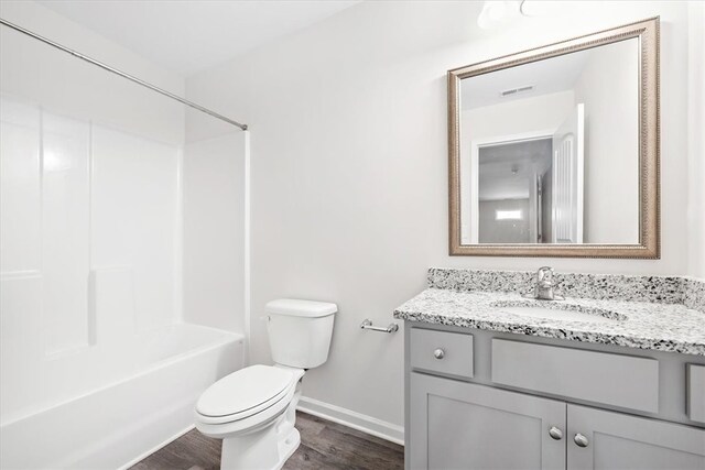 full bathroom with hardwood / wood-style floors,  shower combination, vanity, and toilet