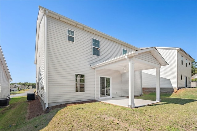 back of house featuring a lawn, central AC unit, and a patio area