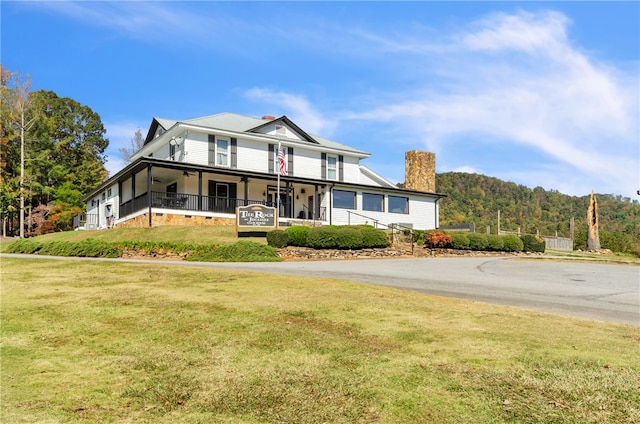 country-style home featuring covered porch and a front lawn