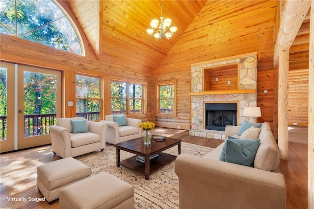 living room featuring a stone fireplace, high vaulted ceiling, wooden ceiling, a chandelier, and light hardwood / wood-style floors