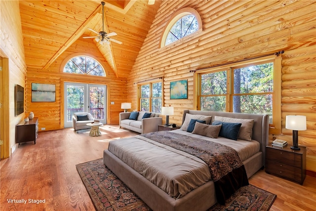 bedroom featuring high vaulted ceiling, multiple windows, and light wood-type flooring