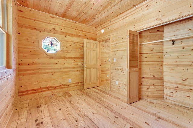 interior space with hardwood / wood-style flooring, wooden walls, and a wealth of natural light