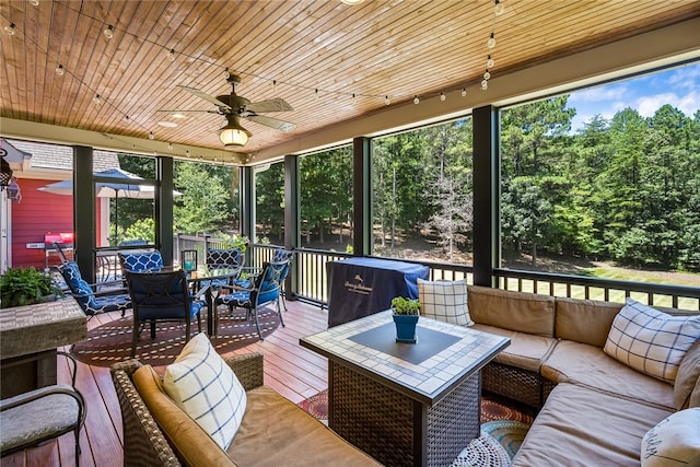 sunroom featuring ceiling fan, wood ceiling, and plenty of natural light