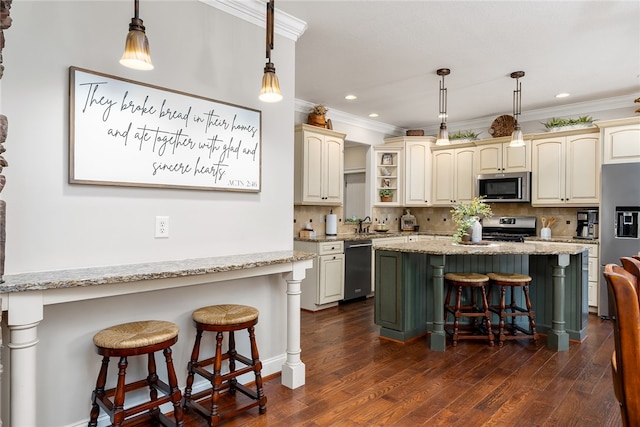 kitchen featuring appliances with stainless steel finishes, cream cabinetry, a kitchen bar, and dark hardwood / wood-style flooring