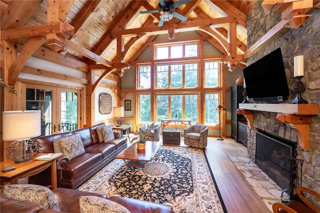 living room featuring high vaulted ceiling, a wealth of natural light, and light hardwood / wood-style flooring