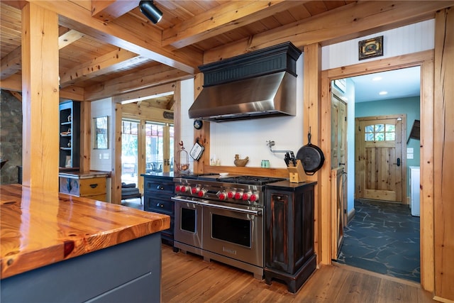 kitchen with wood ceiling, wall chimney exhaust hood, butcher block countertops, hardwood / wood-style flooring, and double oven range