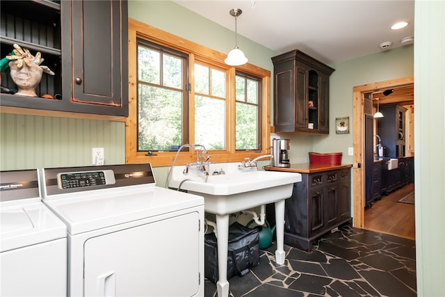 washroom with cabinets, washing machine and dryer, and dark hardwood / wood-style flooring