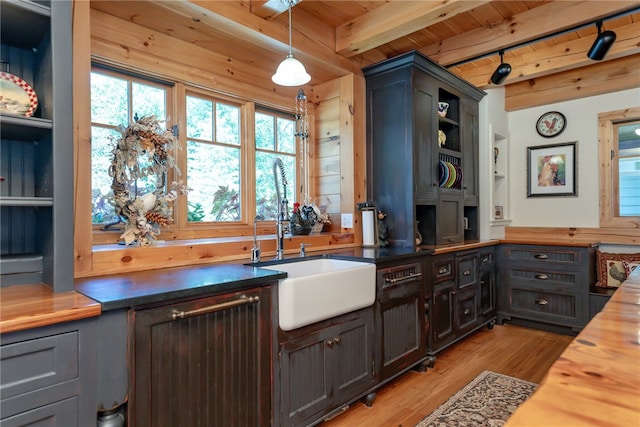 kitchen with wood ceiling, beam ceiling, decorative light fixtures, light hardwood / wood-style flooring, and wood counters