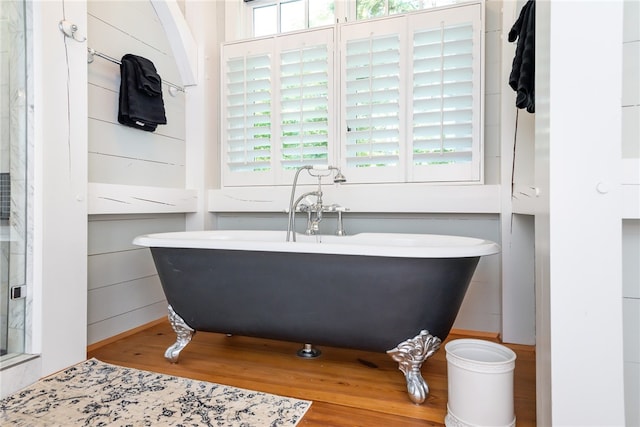 bathroom with hardwood / wood-style flooring, separate shower and tub, and a wealth of natural light