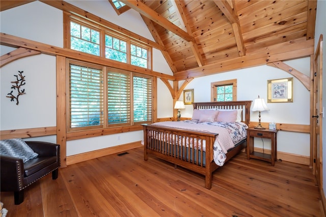 bedroom featuring multiple windows, beam ceiling, and hardwood / wood-style floors