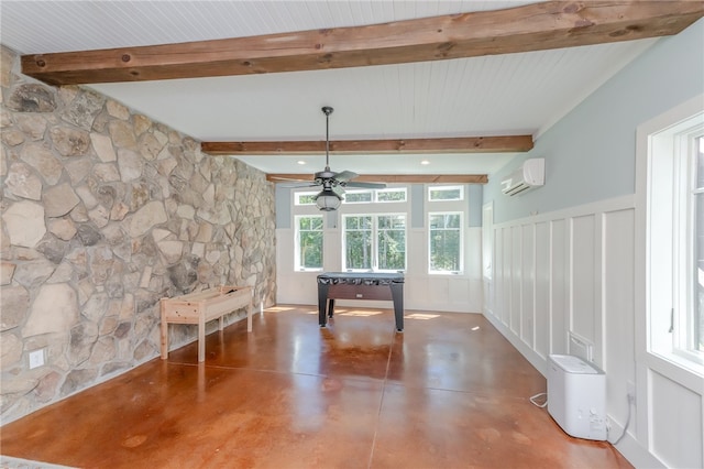 miscellaneous room with a wealth of natural light, beamed ceiling, concrete floors, and a wall mounted AC