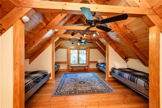 unfurnished bedroom with lofted ceiling with beams, light wood-type flooring, ceiling fan, and wood ceiling