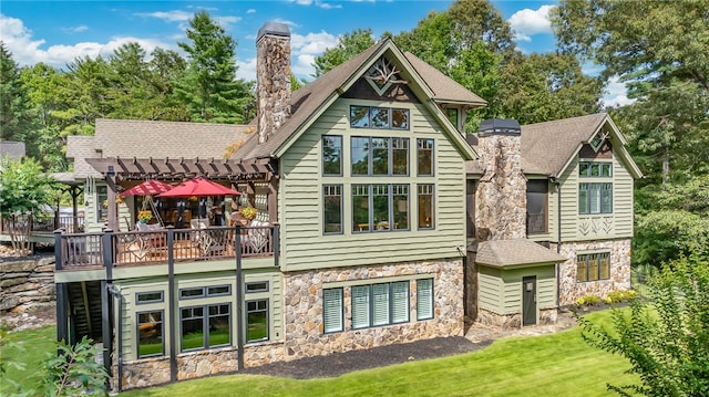 back of house featuring a lawn, a pergola, and a wooden deck