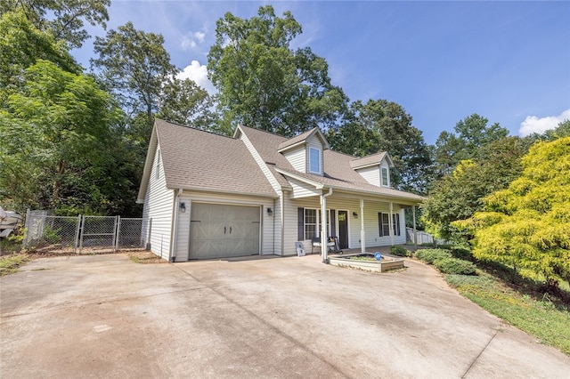 new england style home with covered porch and a garage