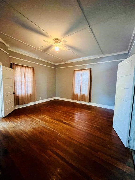 spare room featuring ornamental molding, ceiling fan, and dark wood-type flooring