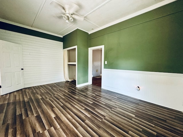 empty room with ceiling fan, dark hardwood / wood-style floors, and crown molding