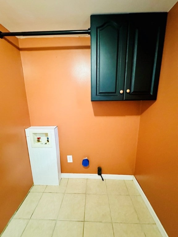 washroom with cabinets, hookup for a washing machine, and light tile patterned floors