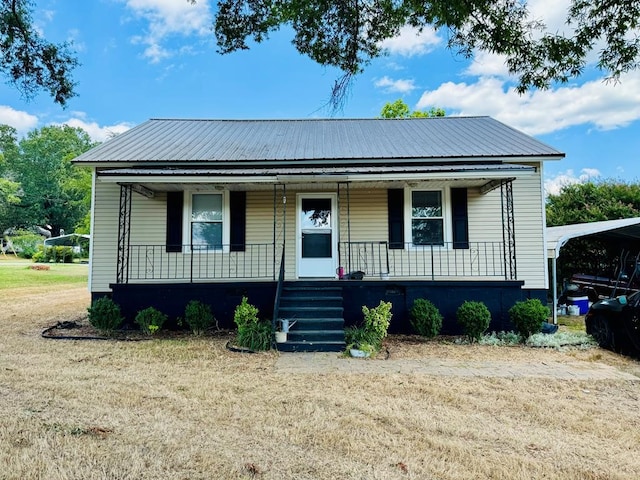 bungalow-style home with a front yard, covered porch, and a carport