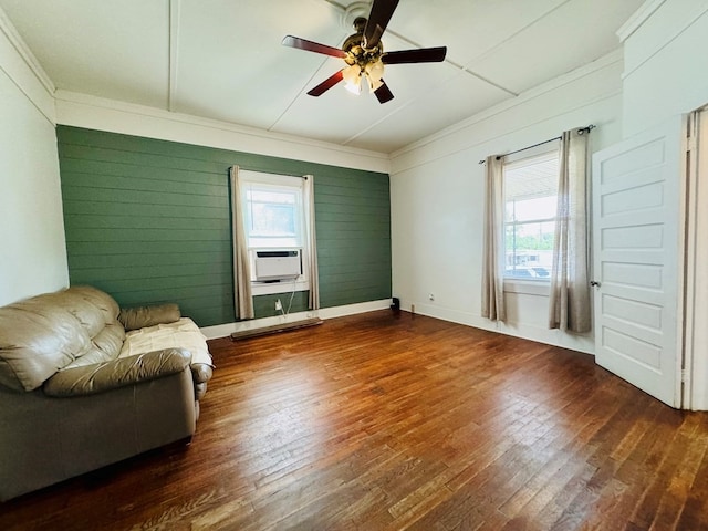 unfurnished room featuring ceiling fan, cooling unit, ornamental molding, wooden walls, and dark wood-type flooring