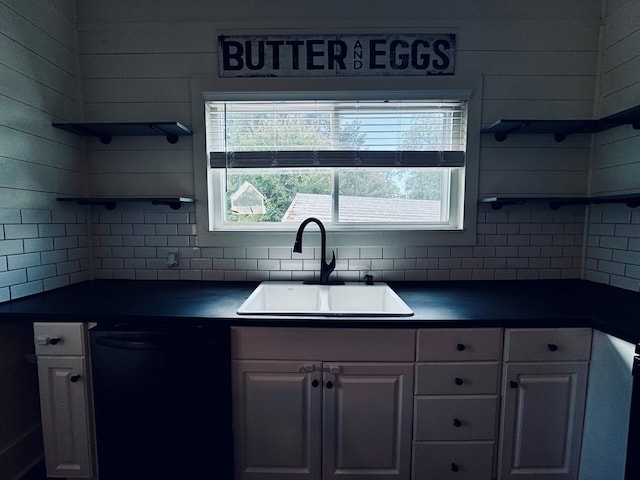 kitchen with black dishwasher, backsplash, sink, and white cabinetry