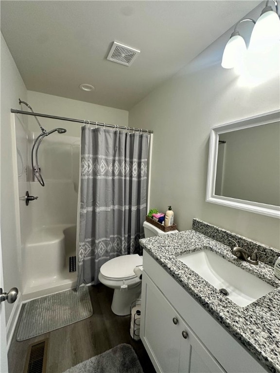 bathroom with vanity, toilet, hardwood / wood-style flooring, and curtained shower