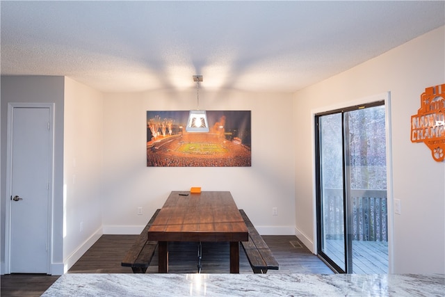 dining area featuring a textured ceiling and dark hardwood / wood-style flooring