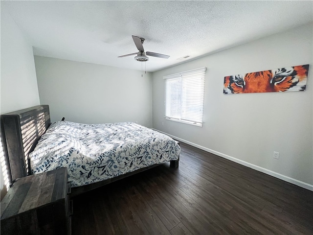 bedroom featuring ceiling fan, a textured ceiling, and dark hardwood / wood-style flooring