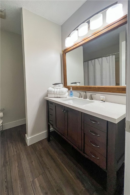 bathroom featuring a textured ceiling, vanity, and hardwood / wood-style flooring