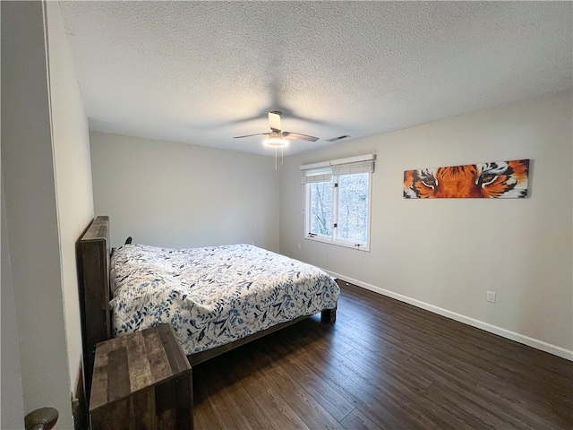 bedroom with a textured ceiling, dark hardwood / wood-style floors, and ceiling fan