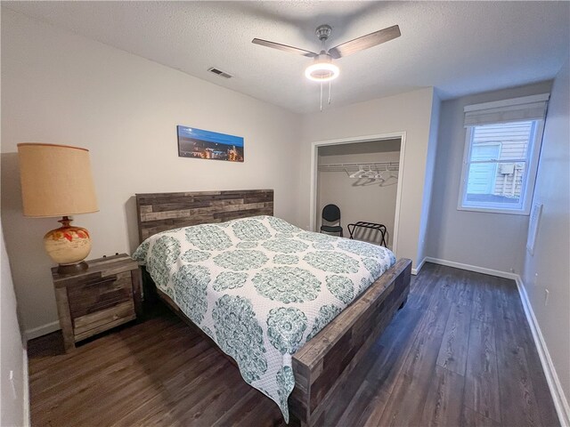 bedroom featuring a closet, dark hardwood / wood-style floors, ceiling fan, and a textured ceiling