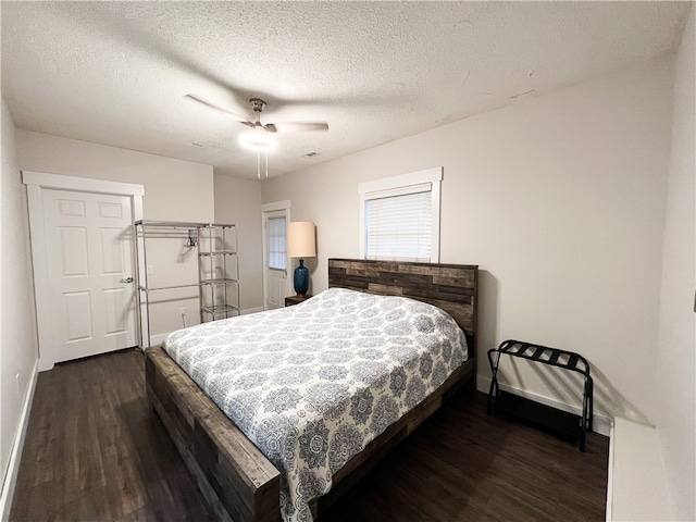 bedroom featuring ceiling fan, a textured ceiling, and dark hardwood / wood-style flooring