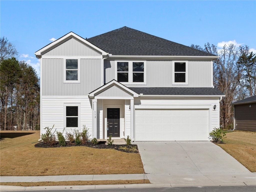 front facade with a front yard and a garage