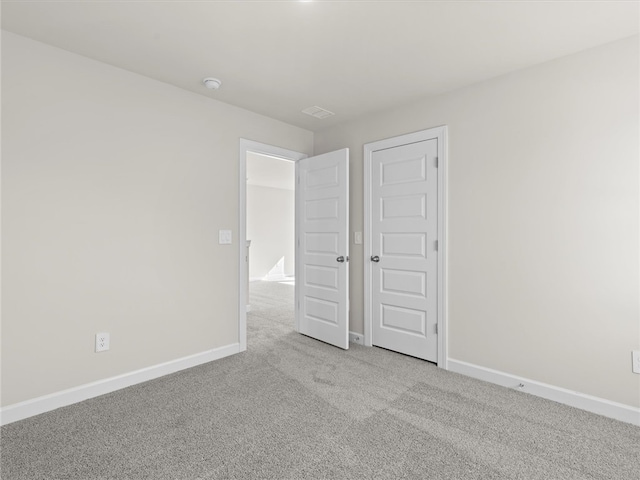 unfurnished bedroom featuring light colored carpet and a closet