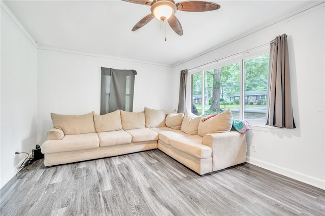 living room with ornamental molding, wood-type flooring, and ceiling fan