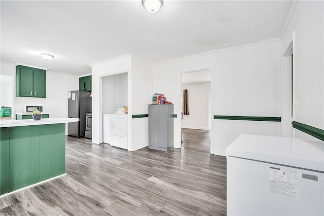 kitchen featuring washer / clothes dryer, stainless steel refrigerator, green cabinetry, ornamental molding, and hardwood / wood-style floors