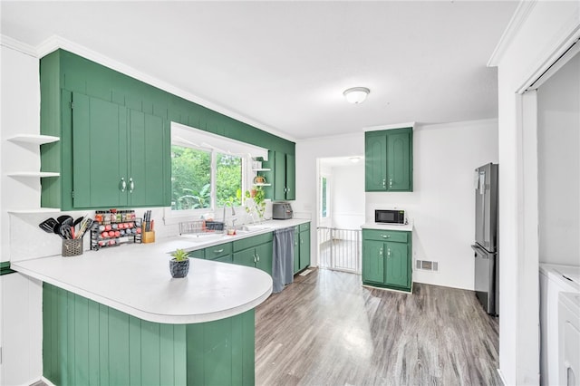 kitchen with green cabinetry, kitchen peninsula, light hardwood / wood-style flooring, appliances with stainless steel finishes, and ornamental molding