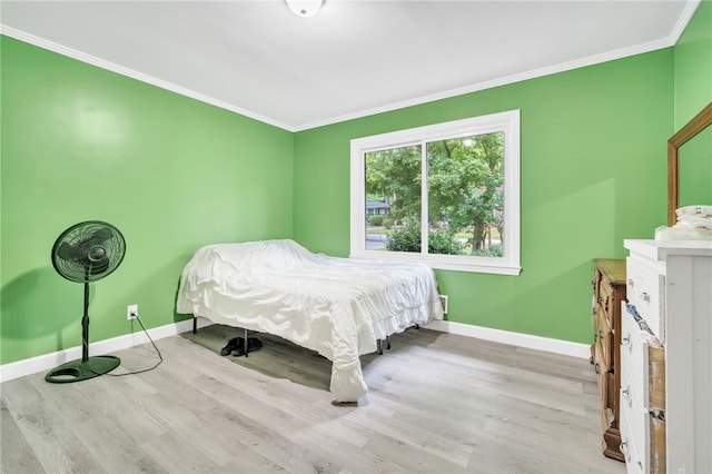 bedroom with light hardwood / wood-style floors and crown molding