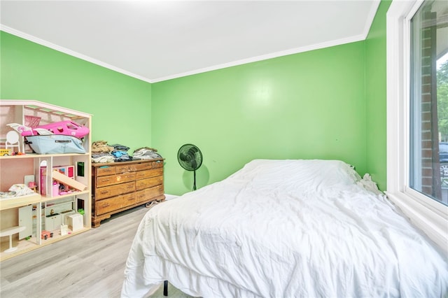 bedroom featuring light wood-type flooring and crown molding