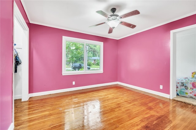 unfurnished room featuring wood-type flooring, ornamental molding, and ceiling fan