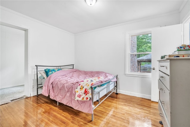 bedroom with hardwood / wood-style flooring and crown molding