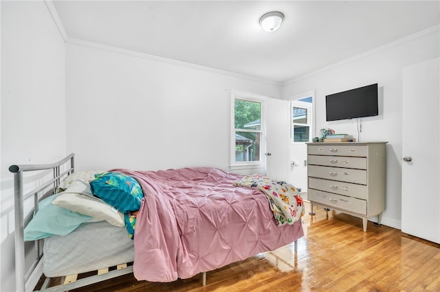 bedroom with ornamental molding and hardwood / wood-style flooring